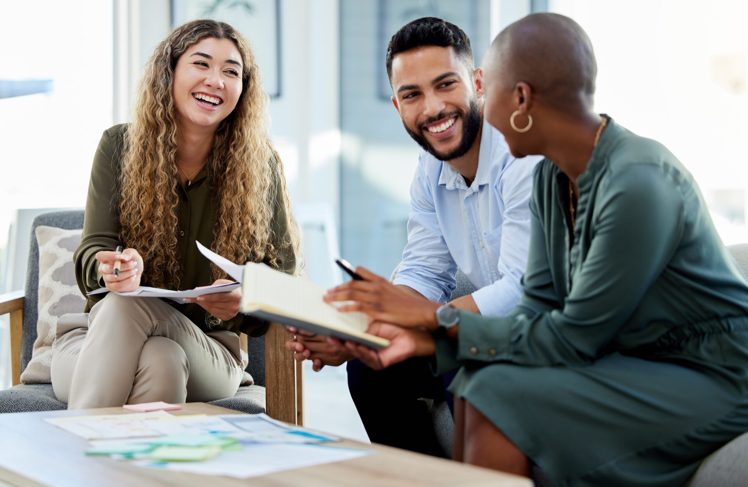 Three people having a meeting, smiling.