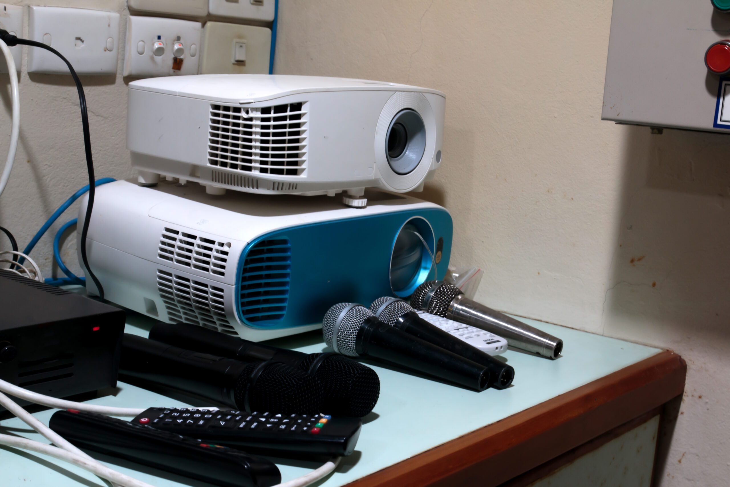 Projectors, microphones, and remotes on a table.