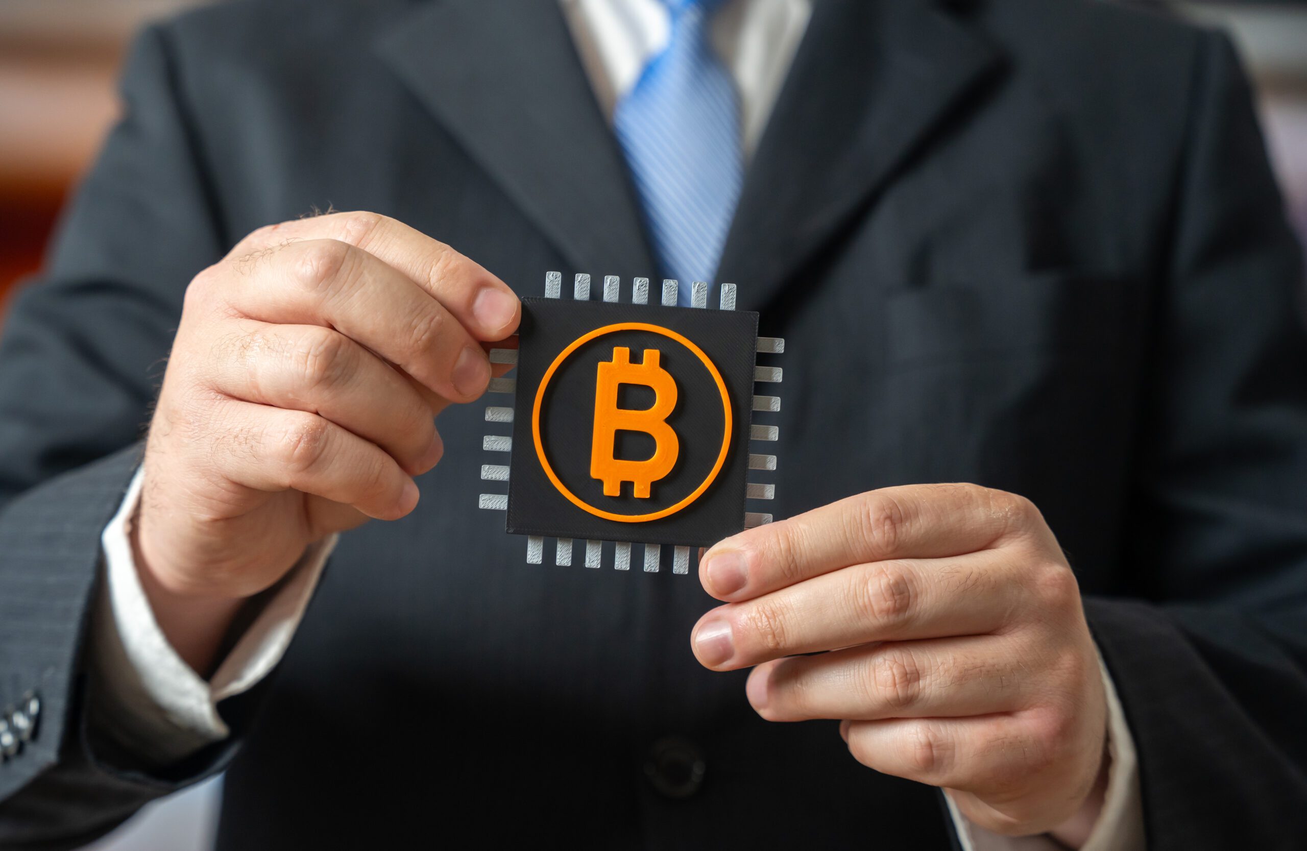 Man holding Bitcoin symbol on chip.