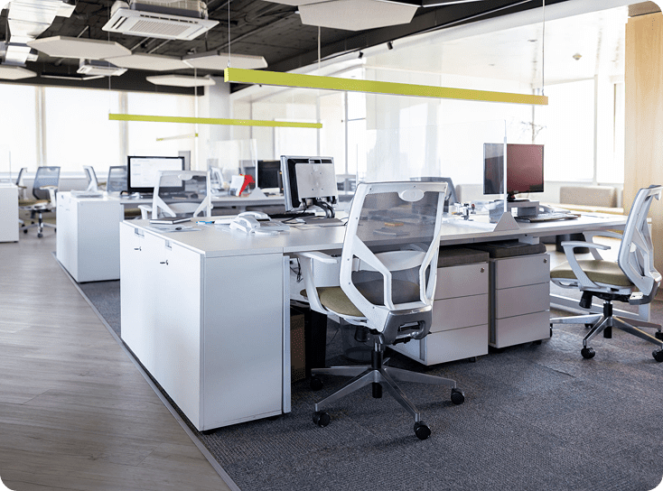 Modern open-plan office with white desks.